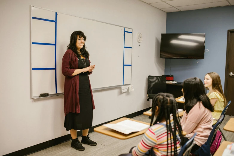 a woman standing in front of a whiteboard in a classroom, academic art, principal set photography, multiple stories, thumbnail, full body image
