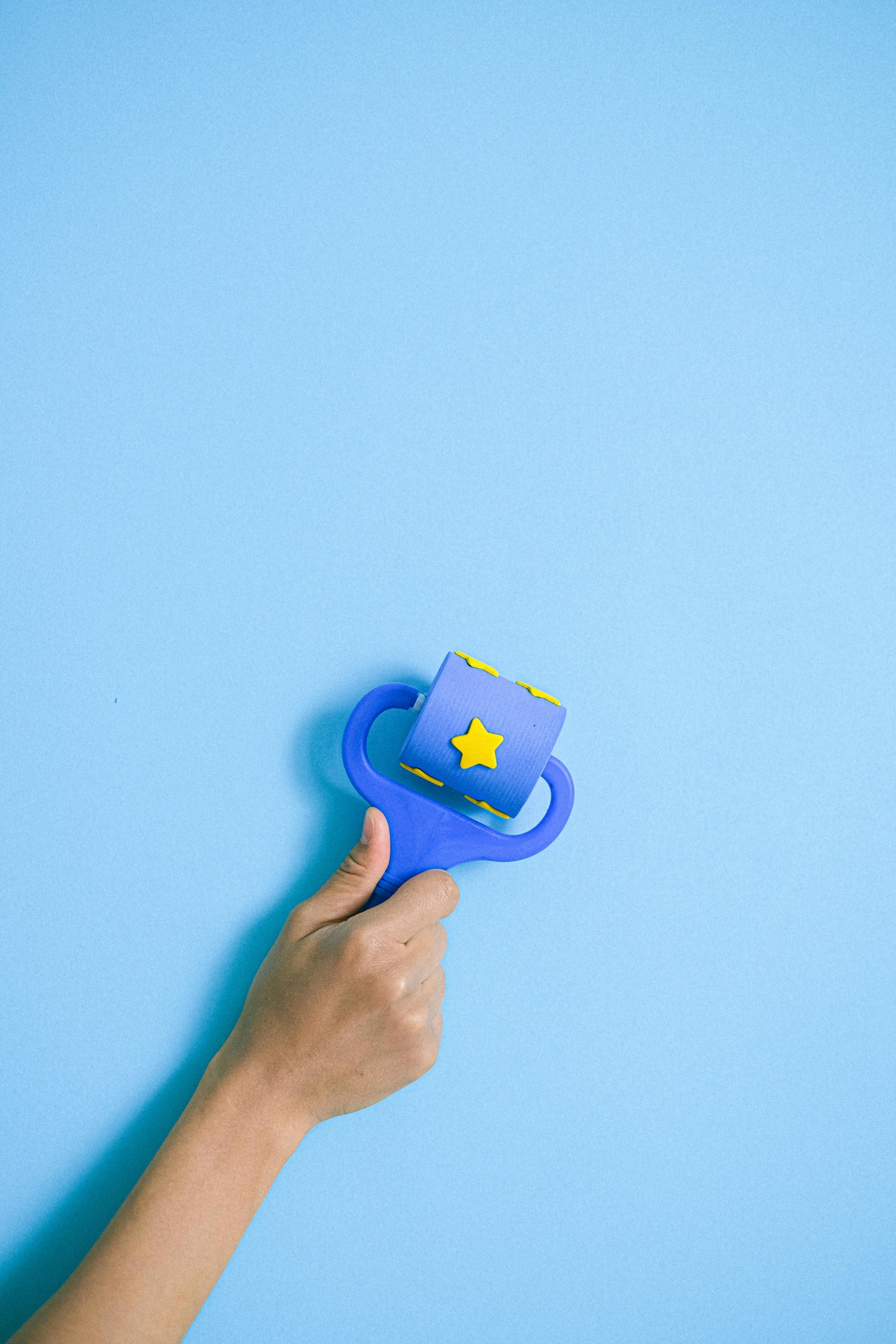 a person holding a blue cup with a star on it, inspired by Mario Bardi, pexels contest winner, holding maracas, toy design, diecut, twirling