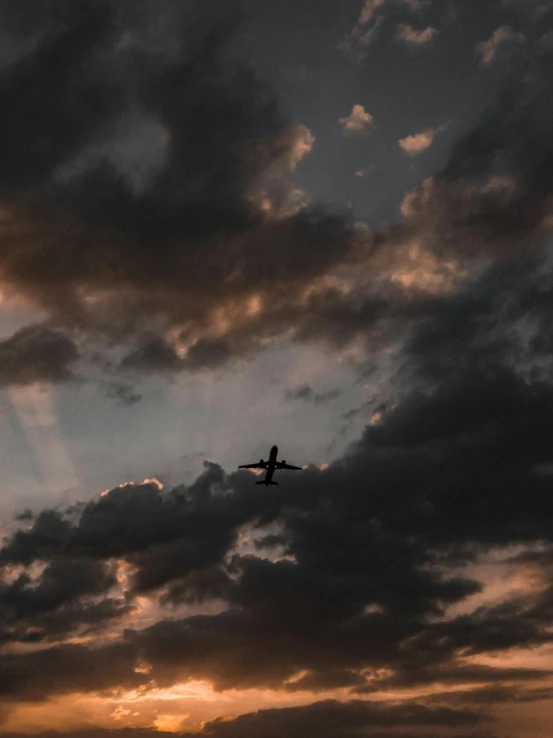 a large jetliner flying through a cloudy sky, by Carey Morris, pexels contest winner, romanticism, ☁🌪🌙👩🏾, trending on vsco, late summer evening, profile picture