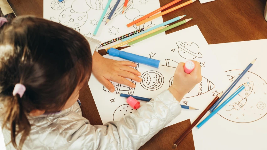 a little girl that is sitting at a table, a child's drawing, pexels contest winner, colouring - in sheet, cute astronaut sticker art, thumbnail, a high angle shot