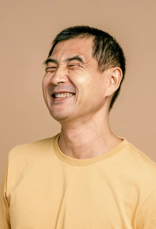 a man laughing while holding a banana in his hand, a character portrait, inspired by Kanō Naizen, trending on pexels, mingei, neck wrinkles, plain background, up close portrait of mr bean, ethnicity : japanese