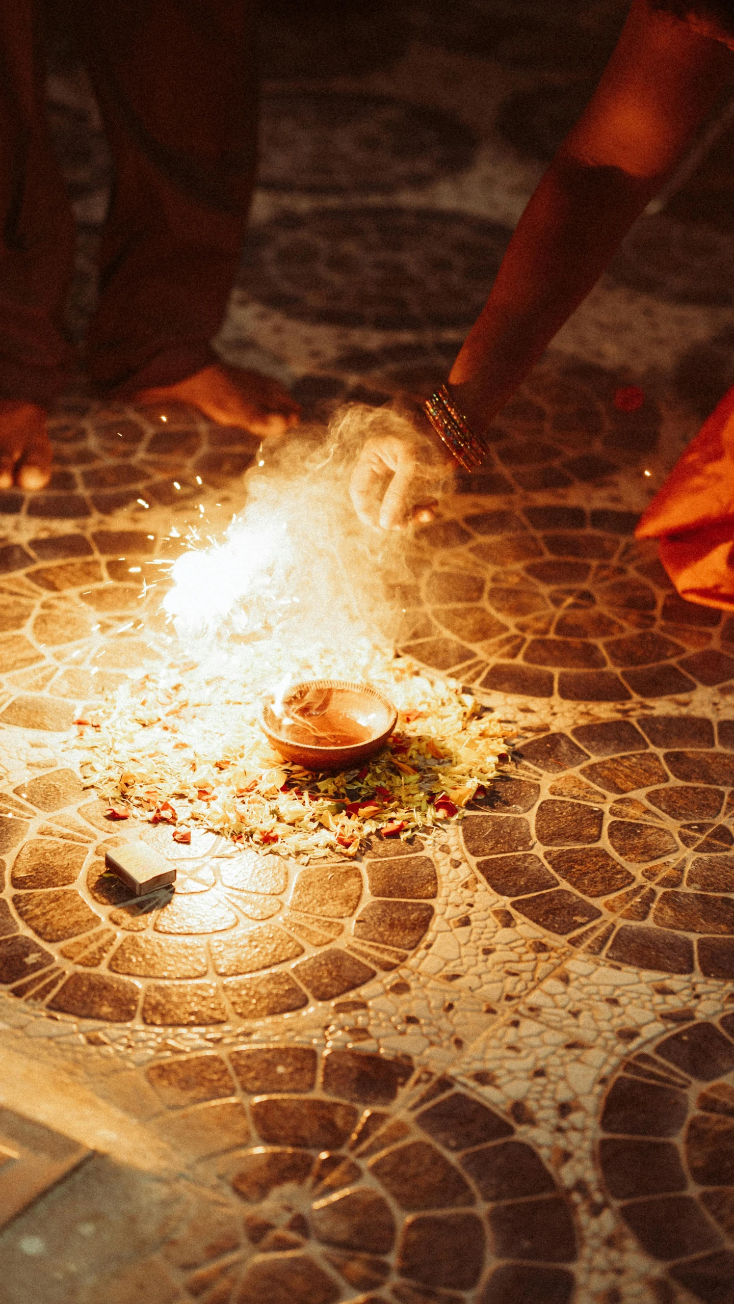 a group of people standing around a fire, hindu ornaments, lighting on concrete, promo image, terrazzo