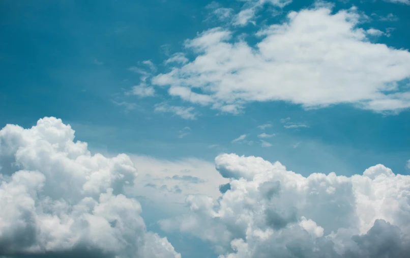 a plane flying through a cloudy blue sky, by Carey Morris, pexels contest winner, romanticism, cumulus clouds, hd footage, multiple stories, high definition photo