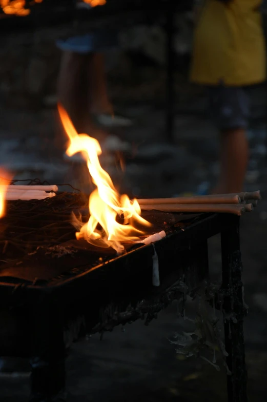 a group of people standing around a fire pit, a close up shot, fusing, burning buildings, yellow charcoal