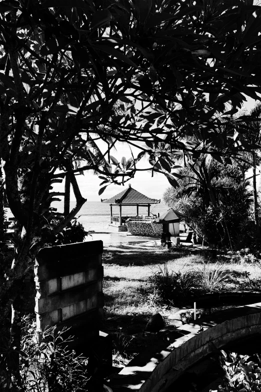 a black and white photo of a park bench, inspired by Max Dupain, small cottage in the foreground, beach and tropical vegetation, gazebos, 1968