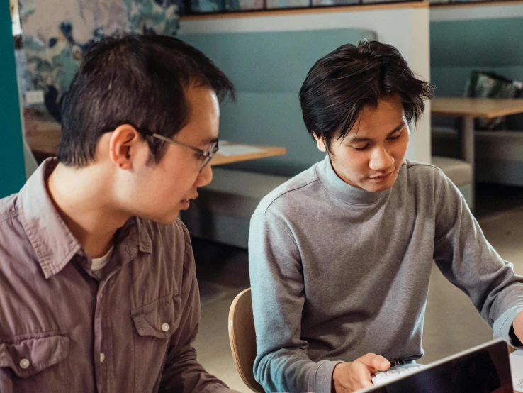 a couple of men sitting at a table with a laptop, pexels contest winner, mingei, mobile learning app prototype, asian descent, background image