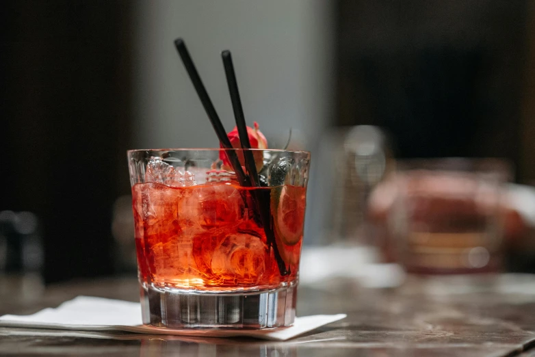 a close up of a drink in a glass on a table, by Carey Morris, unsplash, renaissance, venetian red, obi strip, screwdrivers, battered