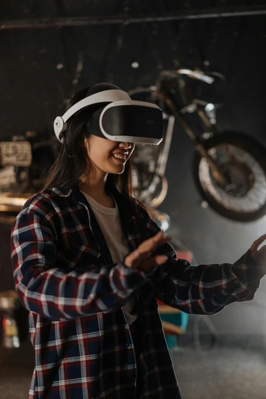 a woman wearing a virtual reality headset in a garage, a hologram, trending on pexels, motorbiker, having fun, ad image, shot with sony alpha