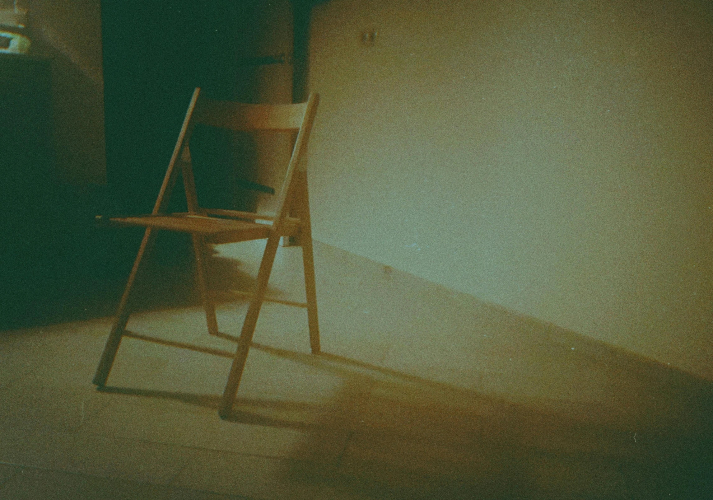 a wooden chair sitting in the corner of a room, a polaroid photo, inspired by Elsa Bleda, pexels contest winner, vhs filter, rinko kawauchi, in a liminal space, grainy movie still