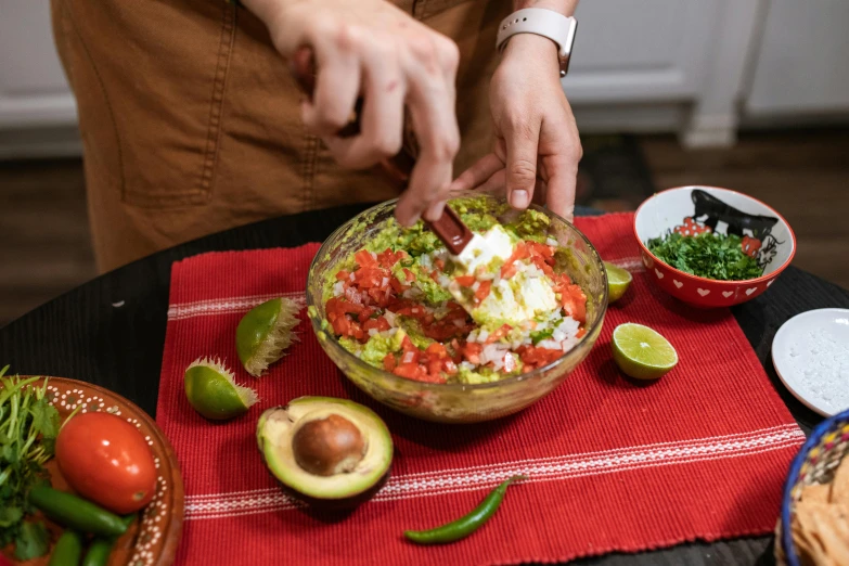 a close up of a bowl of food on a table, by Julia Pishtar, chopping hands, mexican, background image, avocado