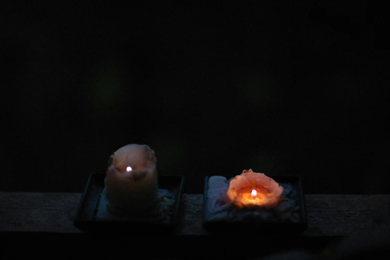 a couple of candles sitting on top of a table, unsplash, mingei, battered, rinko kawauchi, glowing inside, evenly lit