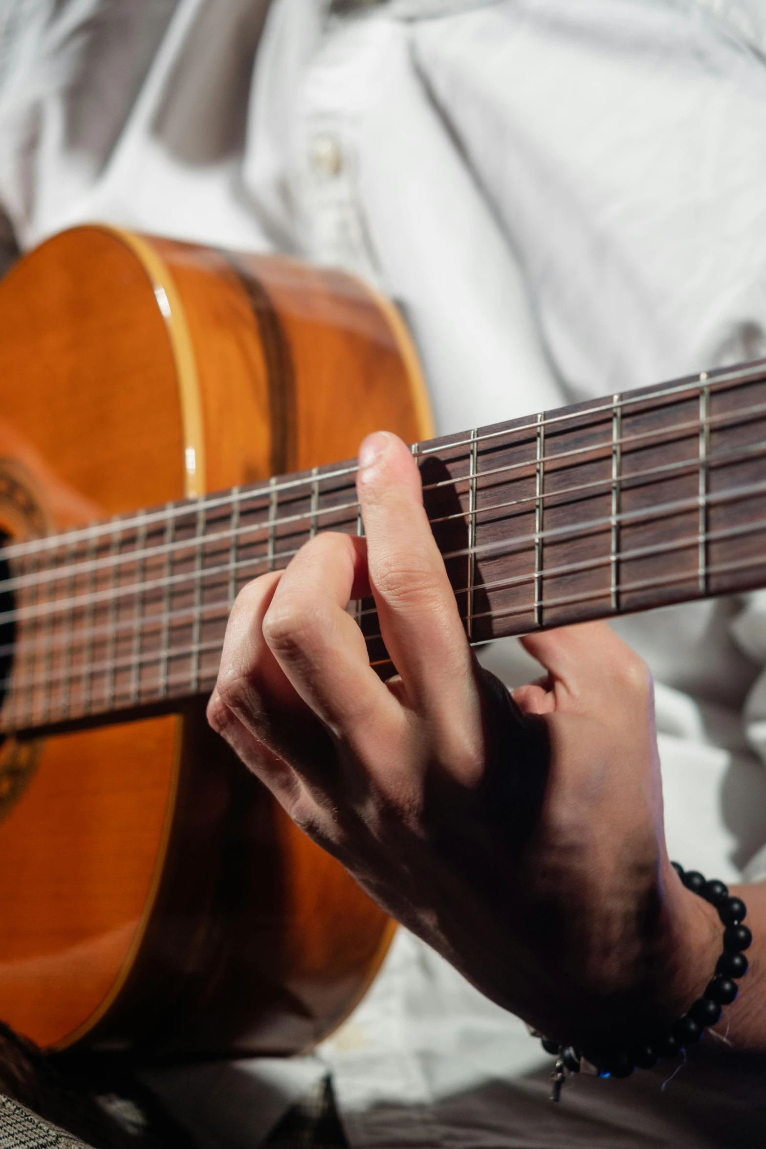 a close up of a person playing a guitar, playing a guitar