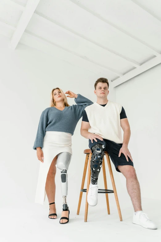 a man sitting on a stool next to a woman, a portrait, trending on unsplash, robotic prosthetic limbs, ripped clothing, low quality photo, full body hero