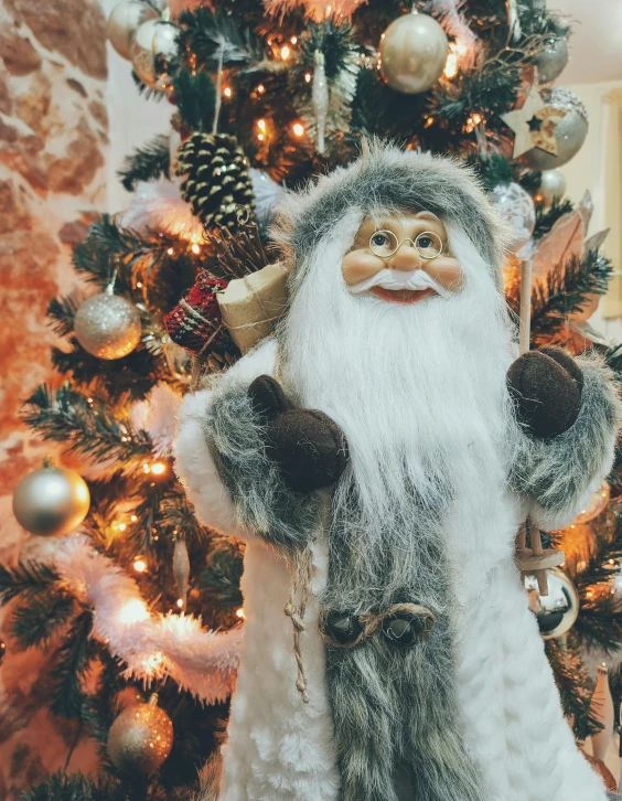 a santa claus figurine standing in front of a christmas tree, a photo, by Julia Pishtar, pexels contest winner, wearing a grey fur robe, brown and white color scheme, anthropomorphic character, seasons!! : 🌸 ☀ 🍂 ❄