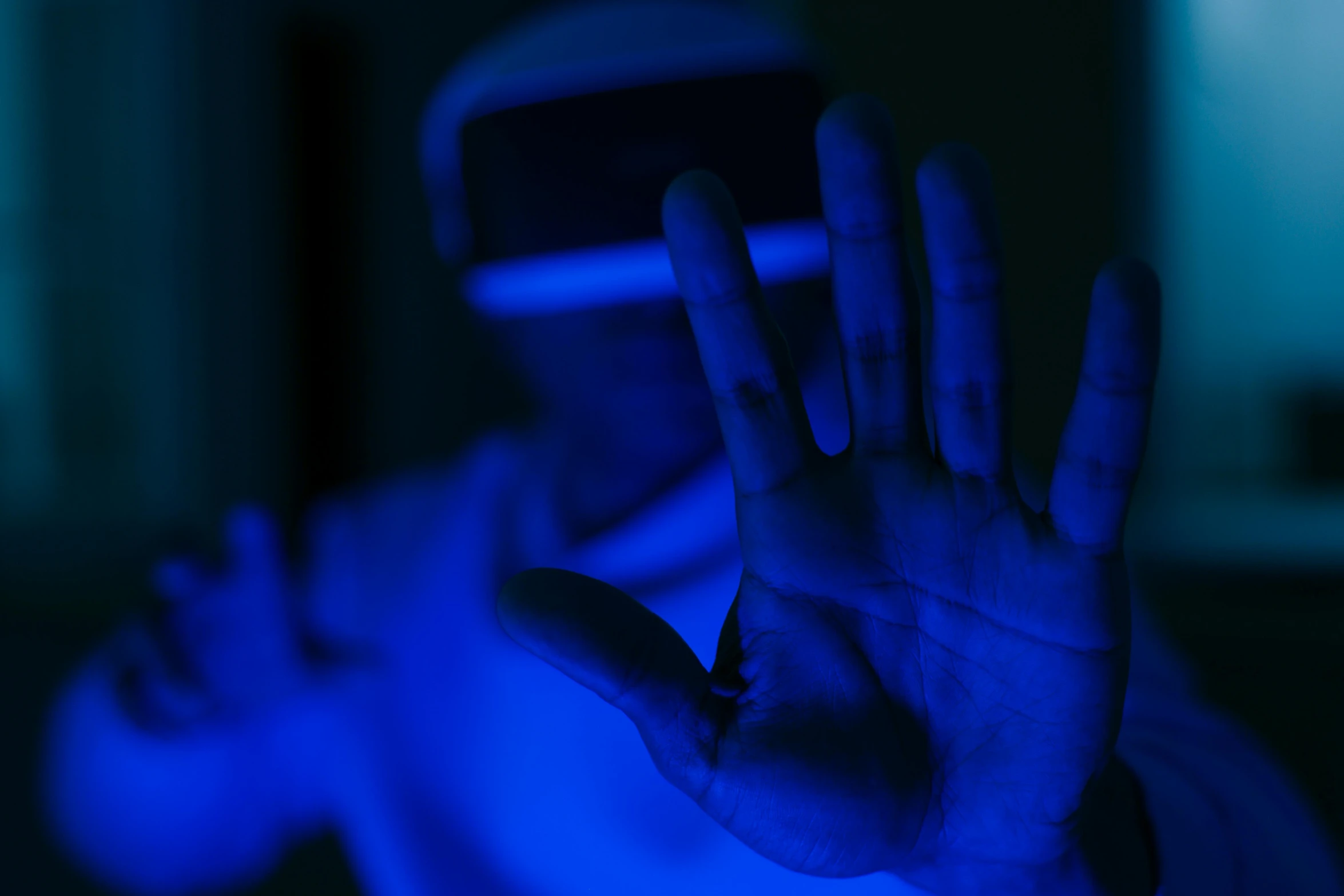 a man wearing a virtual reality headset in a dark room, a hologram, by Adam Marczyński, pexels, closeup of hand, dramatic white and blue lighting, avatar image, volumetric backlighting
