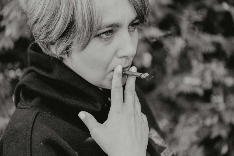a black and white photo of a woman smoking a cigarette, a black and white photo, inspired by Lasar Segall, trending on pixabay, mark hamill, 🤤 girl portrait, jonny greenwood, androgyny