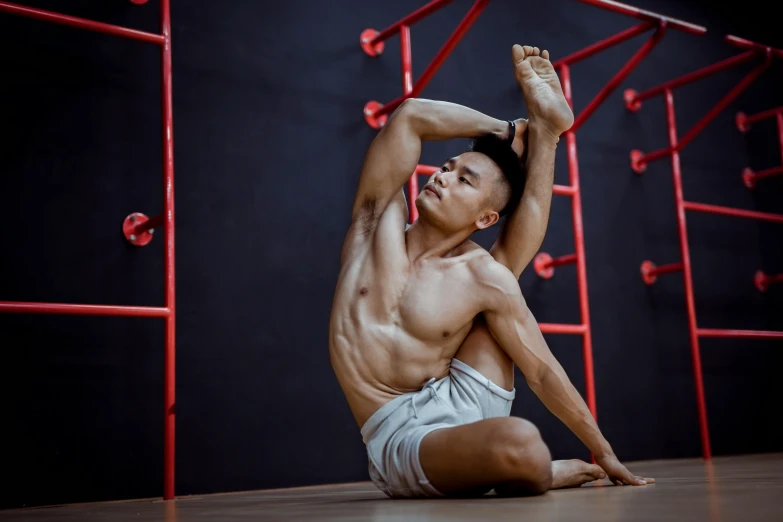 a man sitting on the floor doing a yoga pose, a portrait, pexels contest winner, arabesque, hoang long ly, [ adamantly defined abs ]!!, dim dingy gym, profile image
