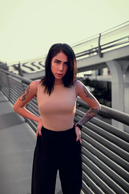 a woman standing on a bridge with her hands on her hips, a tattoo, inspired by Elsa Bleda, better known as amouranth, gif, ultra realistic photo, serious business