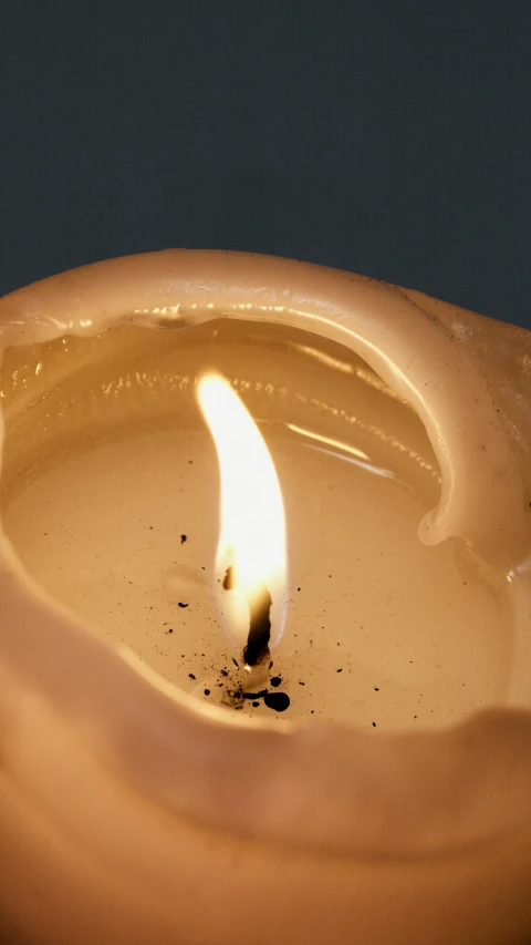 a lit candle sitting on top of a table, highly detailed melted wax, birdseye view, laura watson, medium close-up