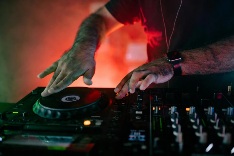 a close up of a person using a dj controller, by Matt Cavotta, pexels, fan favorite, with red haze, mixing drinks, arms out