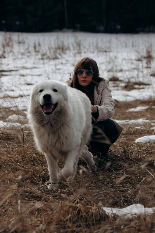 a woman kneeling down next to a white dog, an album cover, inspired by Elsa Bleda, pexels contest winner, siberia!!, buffalo, handsome girl, spring