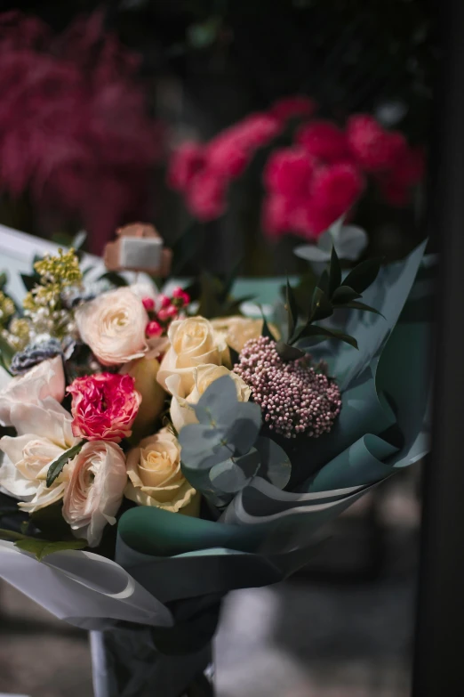 a bouquet of flowers sitting on top of a table, shop front, up close