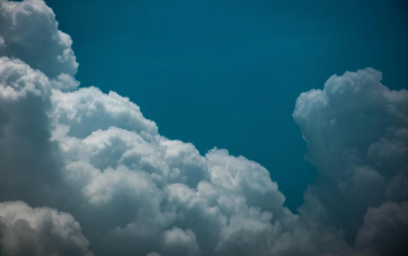 a jetliner flying through a cloudy blue sky, by Adam Marczyński, unsplash, romanticism, towering cumulonimbus clouds, teal sky, hd footage, cotton candy clouds