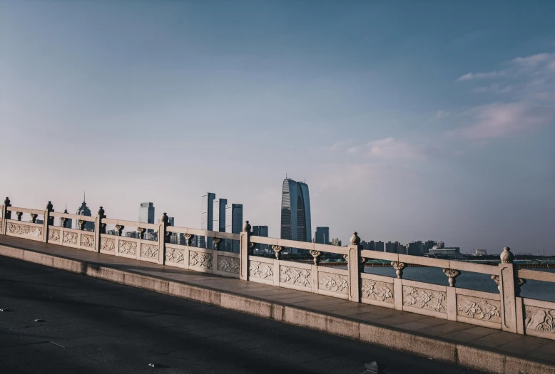 a man riding a skateboard across a bridge, inspired by Cheng Jiasui, pexels contest winner, modernism, city in the distance, background image, beijing, clear skies in the distance