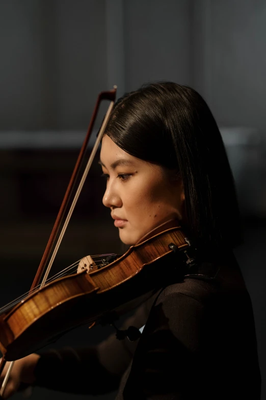 a woman playing a violin in a dark room, leslie zhang, head and shoulder shot, square, looking onto the horizon