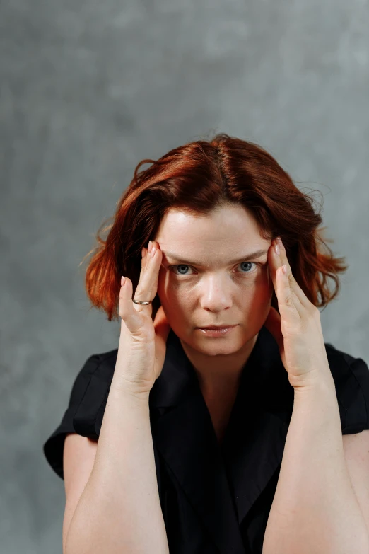 a woman holding her head in her hands, inspired by Anna Füssli, pexels, renaissance, plain background, hr ginger, looking menacing, björk