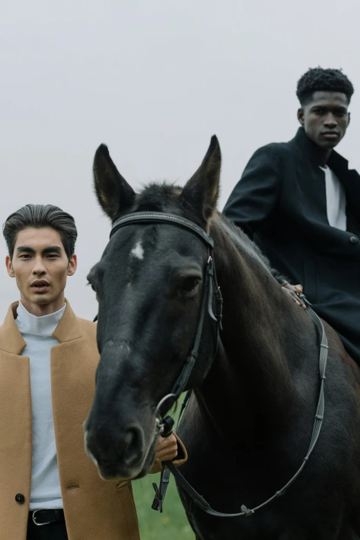 a man riding on the back of a brown horse, an album cover, trending on unsplash, renaissance, grey turtleneck coat, roberto ferri and ruan jia, at a fashion shoot, looking straight to camera