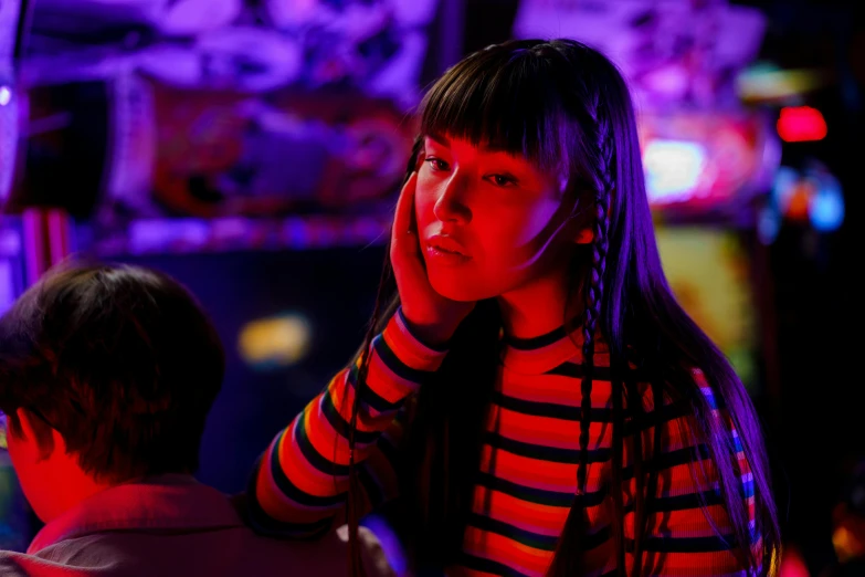 a woman in a striped shirt talking on a cell phone, inspired by Liam Wong, dramatic neon lighting, with full bangs, pensive, film still dnd movie