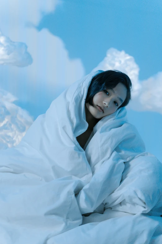 a woman sitting on top of a bed covered in a blanket, an album cover, inspired by Ayami Kojima, unsplash, under blue clouds, avatar image, 奈良美智, modeled