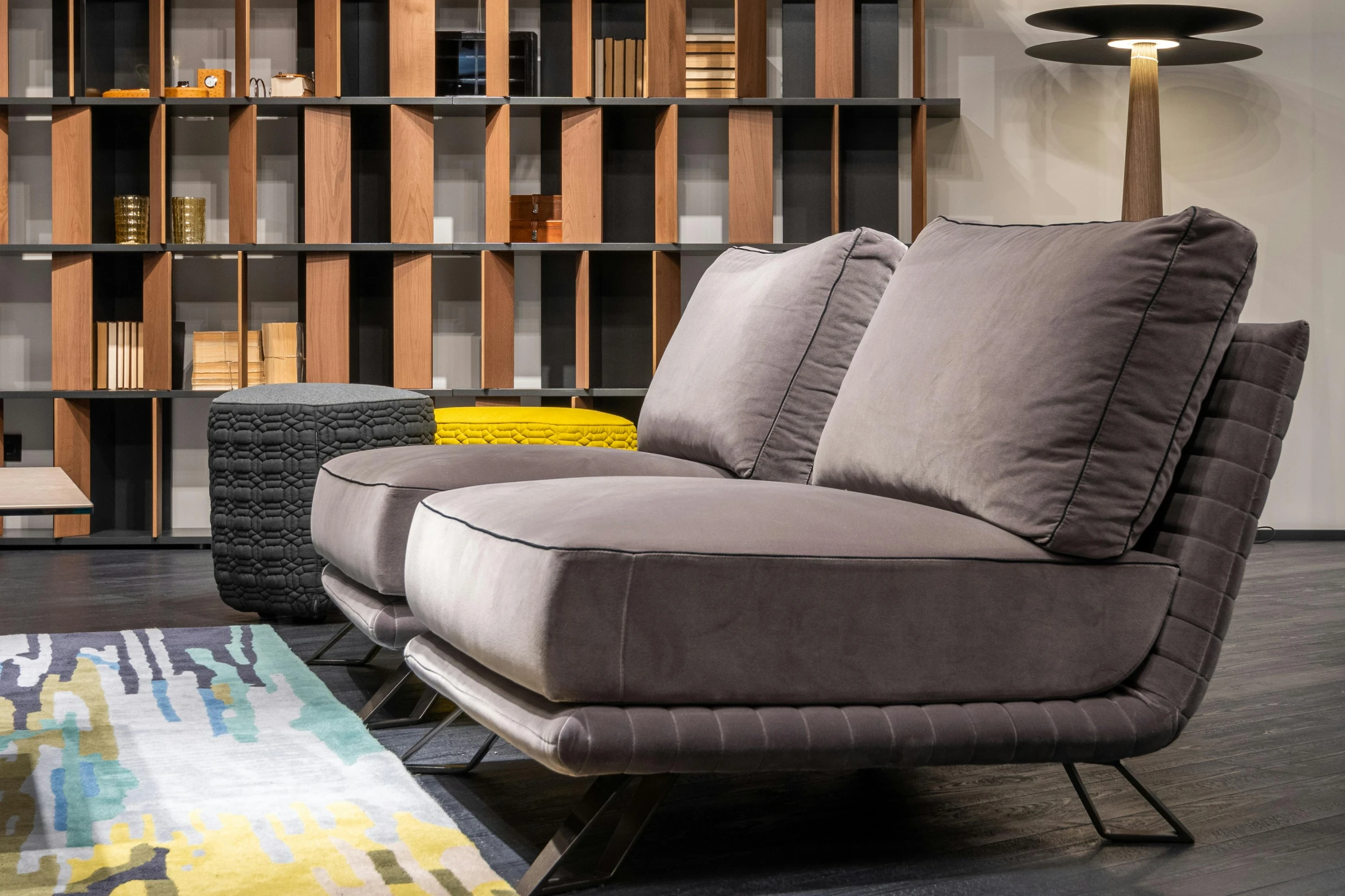 a living room filled with furniture and bookshelves, inspired by Emilio Grau Sala, dynamic closeup, lounge furniture, charcoal and yellow leather, fast