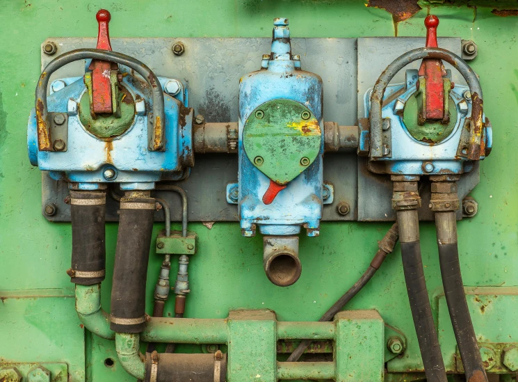 a couple of valves sitting on top of a green wall, a portrait, by Sven Erixson, unsplash, assemblage, heavy machinery, multi - coloured, full frame image