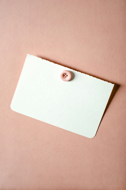 a piece of paper with a button attached to it, by Daniel Seghers, trending on pexels, pastel pink skin tone, card template, 15081959 21121991 01012000 4k, soft vignette