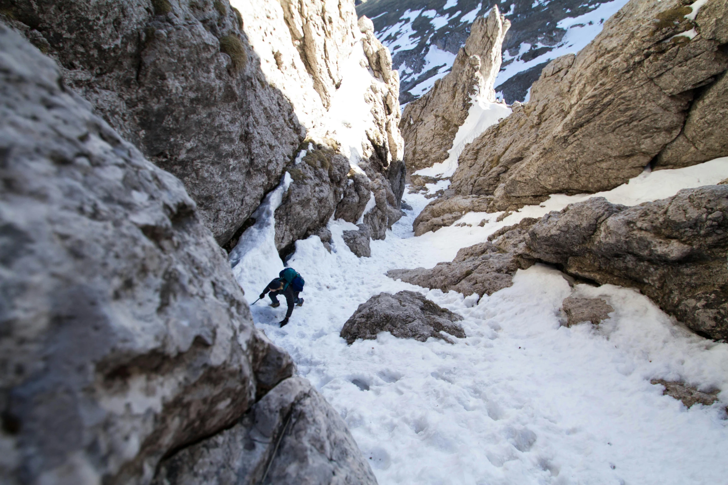 a man riding a snowboard down a snow covered slope, an album cover, by Anna Haifisch, pexels contest winner, rock climbers climbing a rock, narrow passage, thumbnail, rocky roads