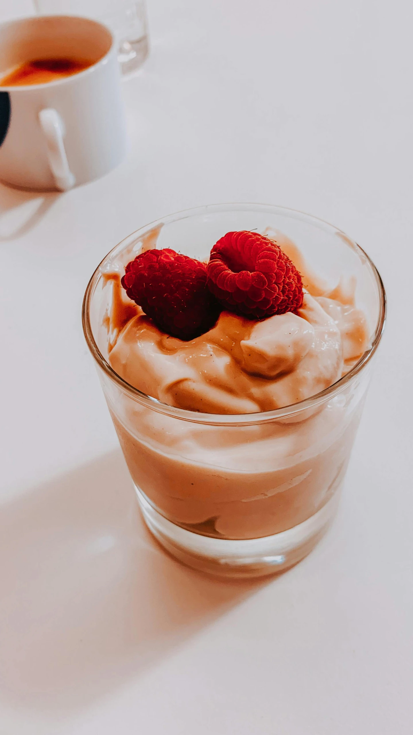 a dessert sitting on top of a table next to a cup of coffee, by Adam Marczyński, unsplash, renaissance, raspberry banana color, cream of the crop, thumbnail, caramel