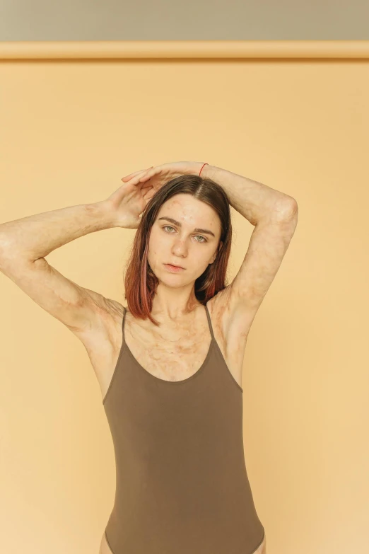 a woman in a brown bodysuit posing for a picture, an album cover, inspired by Elsa Bleda, trending on pexels, emaciated shaved face, hairy arms, androgynous male, h3h3