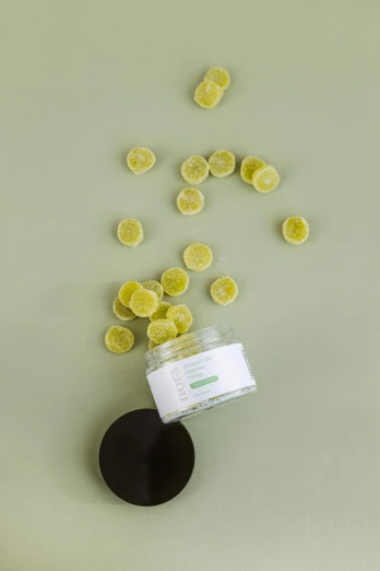 a jar filled with lemon slices on top of a table, detailed product image, green facemask, gumdrops, studio product shot
