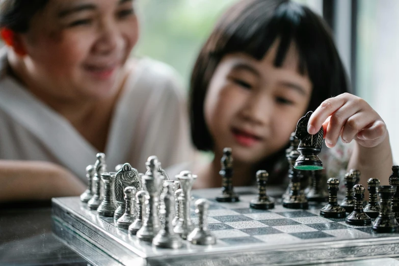 a little girl playing a game of chess with her mother, pexels contest winner, interactive art, asian women, thumbnail, unbeatable quality, fan favorite