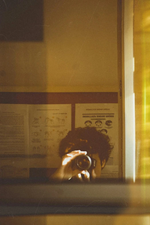 a person taking a picture of themselves in a mirror, by Tobias Stimmer, visual art, dusty library, on a yellow paper, vsco film grain, student