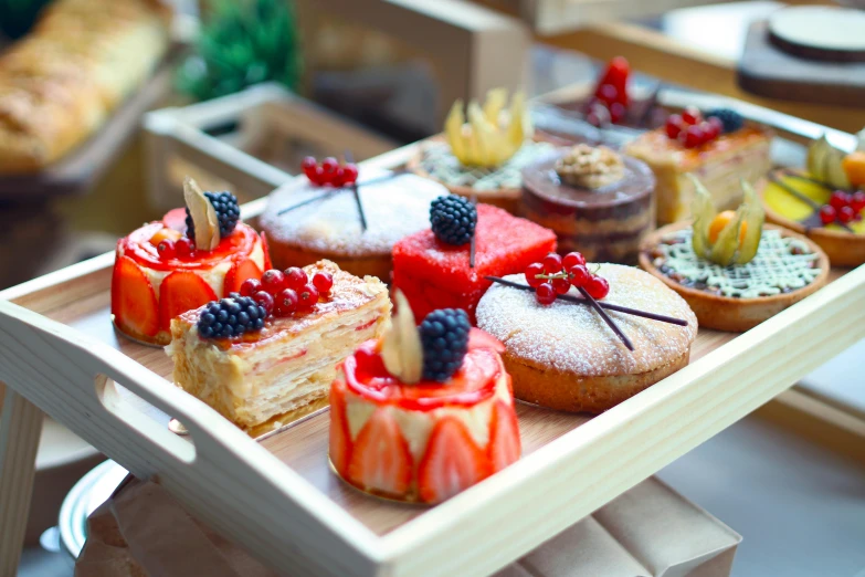 a close up of a tray of food on a table, cakes, about to consume you, fruit, desserts