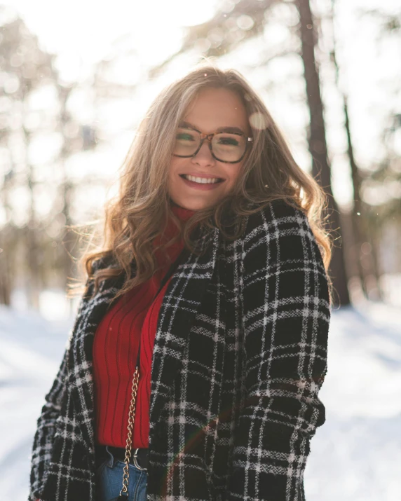 a woman wearing glasses standing in the snow, trending on pexels, happening, smiling seductively, instagram post, flannel, wearing a fancy jacket