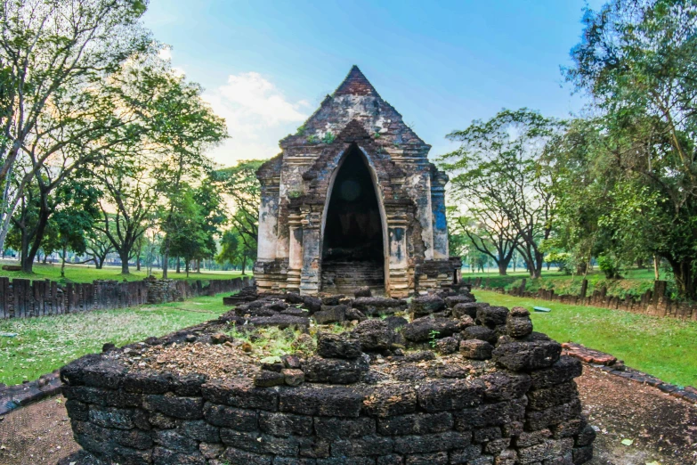 a stone structure in the middle of a park, an album cover, pexels contest winner, sukhothai costume, blue, panoramic, exterior