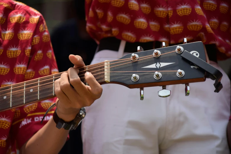 a close up of a person holding a guitar, hurufiyya, maroon and white, schools, jakarta, shorter neck