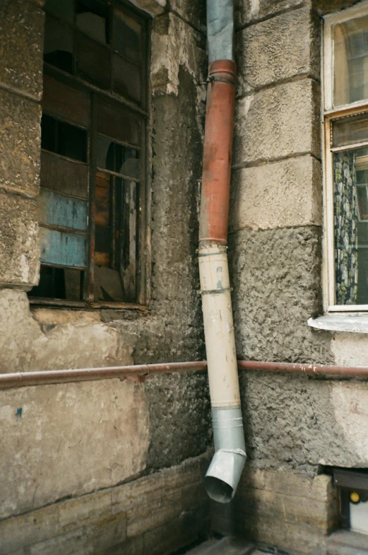 a pipe sticking out of the side of a building, inspired by Zhang Kechun, unsplash, renaissance, sewers, street of moscow, 1990s photograph, old house