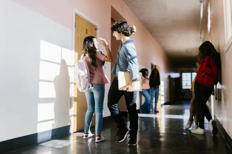 a group of people walking down a hallway, pexels contest winner, happening, teaching, leaning on door, high school girls, on a sunny day