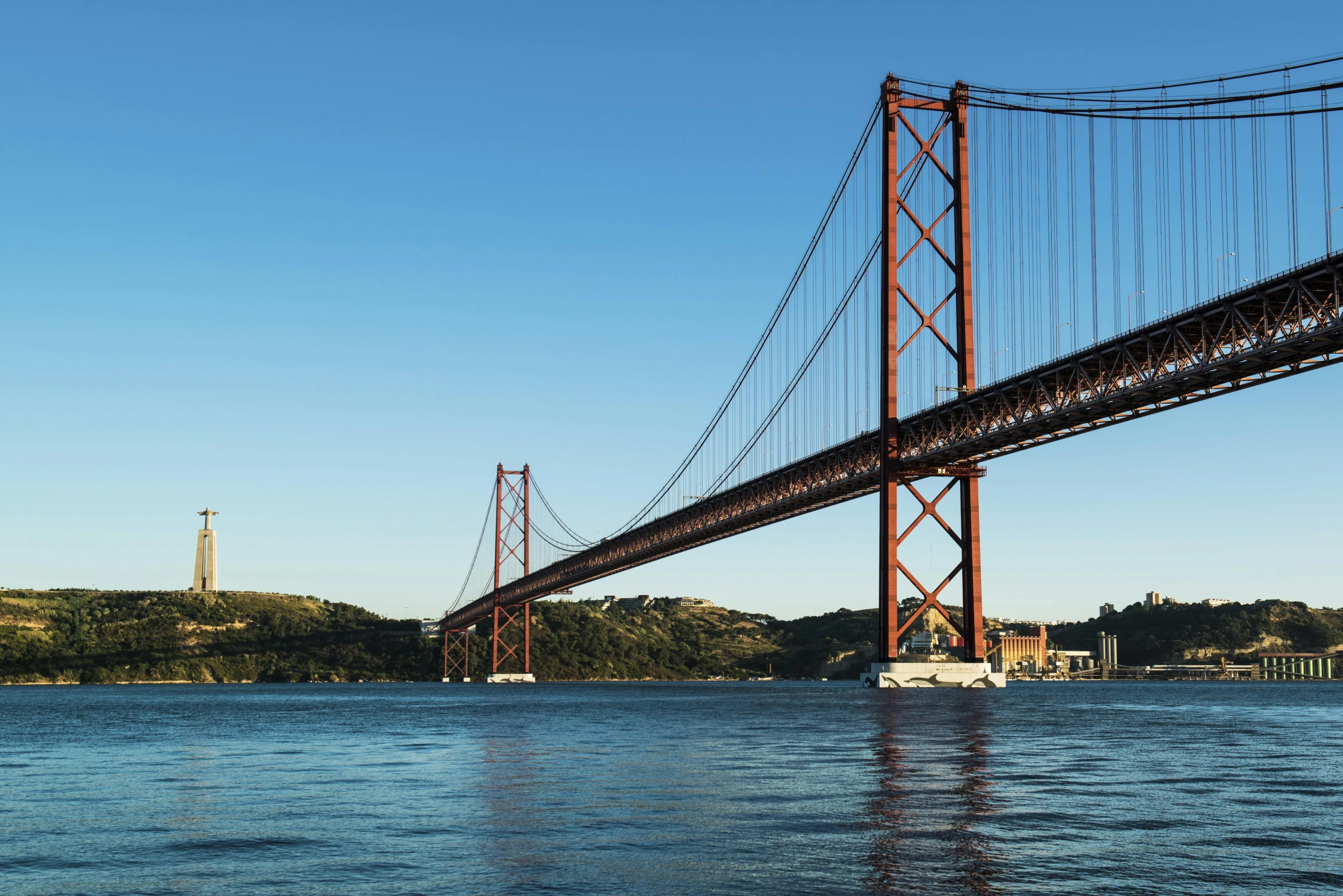 a large bridge spanning over a body of water, inspired by Almada Negreiros, pexels contest winner, two giant towers, red trusses, medium format, mies van der rohe