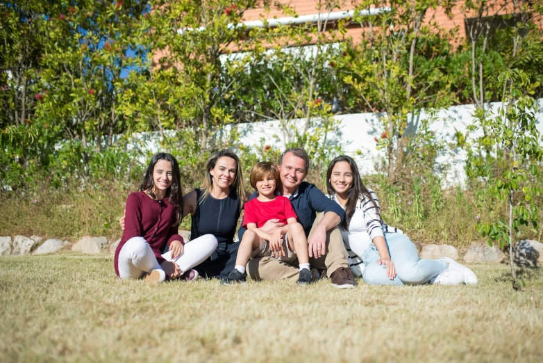 a group of people sitting on top of a grass covered field, a portrait, avatar image, family photography, spanish, clear and sunny